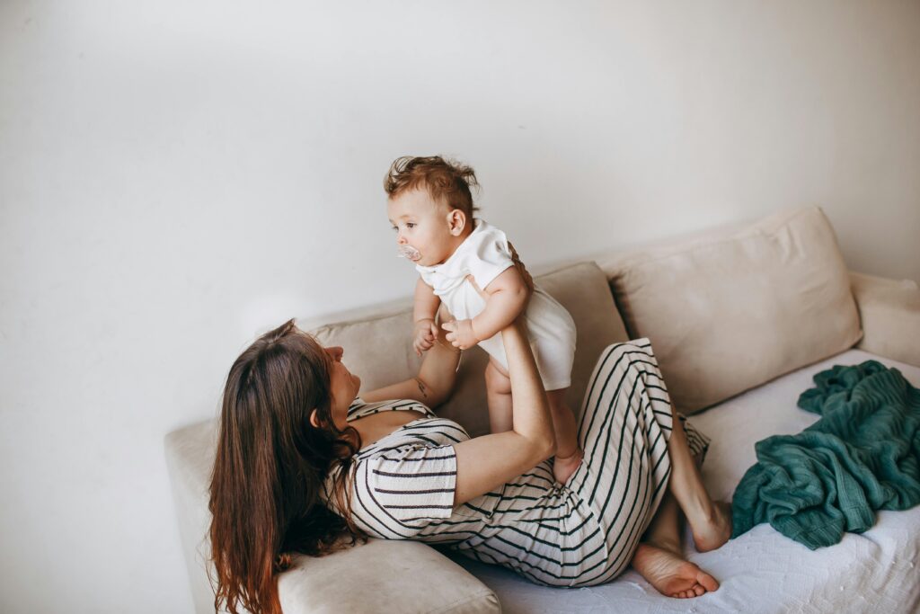 A mother playfully lifts her baby, creating a touching moment of familial love and connection.